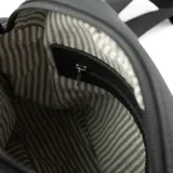 Bandolera negra de cuero con correa ancha ajustable con el logo de la marca estampado.