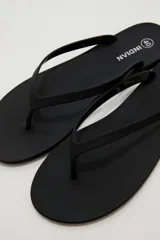 Chancletas negras de diseño clásico y minimalista, con tiras finas de dedo.