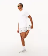 Bermuda de running Get Over para hombre, confeccionada en microfibra ligera de color gris claro. Presenta cintura elástica con cordón ajustable, bolsillos funcionales, dobladillo redondeado con aberturas laterales y pequeño parche con logo de la marca en la pierna izquierda.