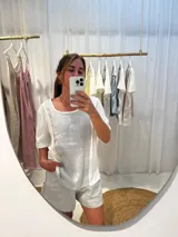 Remera blanca con panel frontal amarillo, detalles de puntilla y corte irregular.