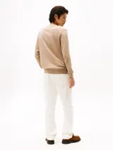 Sweater de punto Tommy Hilfiger con cuello en V, manga larga y puños y bajo acanalados. Presenta un diseño liso en color beige con el logo de la marca bordado en el pecho.