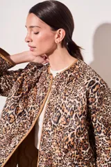 Campera color camel con diseño acolchado, cierre con botones a presión, cuello de piel sintética desmontable, bolsillos delanteros y puños ajustables con lazo.