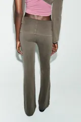 Pantalón de tiro alto con cintura doblada y diseño acampanado, confeccionado en tejido de algodón con efecto lavado. Presenta un detalle de aplicación de brillos en la cintura.