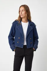 Trench de denim azul oscuro con diseño cruzado de doble botonadura, solapas amplias, trabillas en los hombros y puños ajustables.