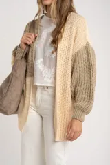 Cardigan de punto grueso con diseño color block en tonos beige, crema y verde oliva. Corte oversize y mangas largas.