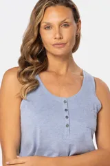 Musculosa blanca sin mangas, de corte clásico y calce cómodo, confeccionada en tejido suave. Presenta escote redondo, cartera con botones frontales y un pequeño bolsillo aplicado en el pecho.