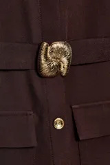 Vestido midi sin mangas de cuello redondo, con cierre frontal de botones dorados y cinturón integrado con hebilla metálica. Presenta bolsillos delanteros con solapa y una abertura en el bajo frontal.