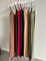 Vestido largo color beige, de viscosa, con tirantes finos, escote en V y aberturas laterales en la falda.