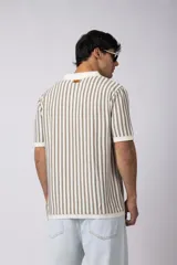 Chomba de tejido de punto con diseño de rayas verticales en tonos beige y marrón, cuello polo y mangas cortas con terminación acanalada.