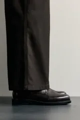 Zapato de cordones tipo blucher color marrón oscuro, confeccionado en piel con horma redonda y suela con ligero tacón.