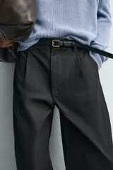 Pantalón de corte wide fit confeccionado en algodón con efecto lavado. Presenta pliegues frontales, bolsillos laterales y bolsillos traseros de vivo. Cierre frontal con cremallera y gancho metálico oculto.