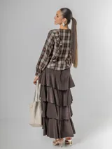 Falda larga de micro corderoy color marrón oscuro, con diseño de volados en capas y elástico en toda la cintura.