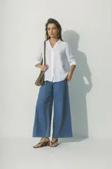 Camisa blanca de lino con cuello clásico, manga larga con puños abotonados y cierre frontal con botones. Corte recto y holgado.