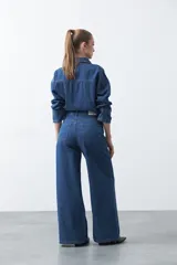 Jean wide leg de color negro con silueta amplia y caída fluida. Presenta detalles de tachas aplicadas que recorren el diseño en forma de ondas. Confeccionado en denim de algodón.