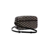 Bolso bandolera Goyard Saint Cap-Vert PM en color negro con el característico estampado geométrico de la marca en tonos marrones y blancos. Cuenta con cierre de cremallera, bolsillo frontal plano y correa ajustable de cuero negro con hebilla metálica.