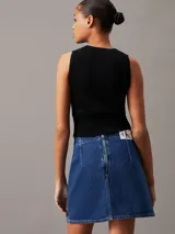 Musculosa Calvin Klein de corte slim, confeccionada en tejido de punto de canalé suave y elástico. Presenta cuello redondo, diseño sin mangas y una insignia con el monograma de la marca en el pecho.