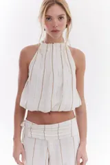 Blusa crop estilo halter con diseño abullonado en la parte inferior, confeccionada en lino con estampado de rayas verticales sutiles.