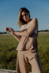 Conjunto de dos piezas compuesto por un top sin mangas con diseño bicolor en blanco y negro y detalle bordado frontal, y un pantalón de corte recto y ancho en color negro con bolsillos laterales y cintura ajustable.