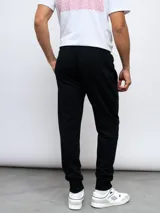 Pantalón de jogging gris melange con puños ajustados en los tobillos y cordón en la cintura. Presenta el logo Umbro bordado en negro en la pierna izquierda.