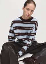 Sweater de punto fino con diseño oversize y patrón de rayas horizontales en tonos marrón, celeste y blanco. Cuenta con cuello redondo y mangas largas.