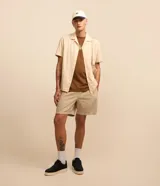 Bermuda masculina color beige claro, con textura, cintura elástica ajustable con cordón y bolsillos laterales.