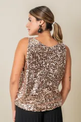 Blusa sin mangas confeccionada en tela cubierta de lentejuelas doradas y plateadas, con escote redondo y corte holgado.