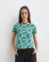 Remera de manga corta con estampado estilo acuarela en tonos de turquesa, verde y blanco, de cuello redondo y corte ajustado.