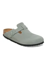 Zueco Birkenstock modelo Boston, confeccionado en gamuza color verde salvia. Presenta una tira ajustable con hebilla metálica al tono, plantilla anatómica de corcho y suela de goma negra.