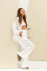 Pantalón blanco de tiro alto, de corte holgado y pernera ancha, con cintura elástica fruncida y cordón ajustable delantero.