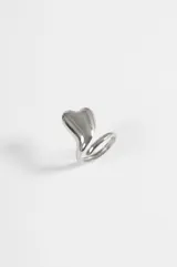Anillo ajustable de acero quirúrgico con diseño de corazón voluminoso y superficie lisa pulida.