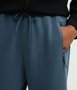Pantalón jogger deportivo de hombre en color azul, con cintura elástica ajustable con cordón, bolsillos laterales con cierre de cremallera y bajo ajustado con puño elastizado.