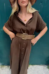 Vestido midi marrón con cuello solapa, escote en pico, mangas cortas con vuelta y cierre frontal con botones. Incluye un cinturón ancho a juego con hebilla metálica rectangular.