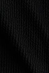 Malla enteriza de punto texturizado color negro, con escote en V, tirantes dobles finos ajustables y copas con relleno extraíble. Presenta piernas de corte alto y diseño completamente forrado.