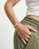 Pulsera de cuentas de aleación de metales bañadas en plata de ley, con cuenta central mayor y ajuste de cuero marrón.