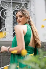 Vestido largo de gasa color verde esmeralda, con cuello halter, drapeado en el corpiño y falda plisada. Incluye lazos a los costados del cuello que permiten múltiples formas de uso.