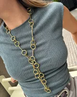 Collar dorado con eslabones grandes y un dije central en forma de Y con círculos.