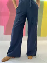 Mono largo azul marino con estampado dorado en la parte superior, cuello mao, sin mangas, con cinturón y bolsillos laterales.