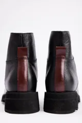 Borcegos de cuero color marrón con cierre frontal y suela track negra.