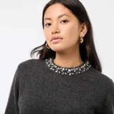 Vestido tipo sweater de punto color gris oscuro, con corte recto, mangas largas y detalle de pedrería (strass) en el cuello redondo.