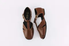 Zapatos bajos color verde oliva de cuero, con tira sobre el empeine y hebilla dorada.