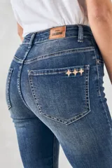 Jeans de denim azul oscuro, corte skinny y tiro medio.