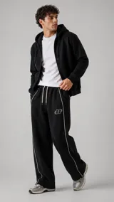 Pantalón de jogging negro, de corte ancho y relajado, con cordón ajustable en la cintura, ribetes blancos contrastantes en los laterales y pequeño logo bordado en la pierna izquierda.