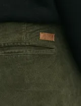 Pantalon de pana de corte clasico, color verde oliva, con bolsillos delanteros inclinados y bolsillos traseros de ribete.
