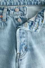 Jean tobillero de cinco bolsillos en denim de algodón rígido, con piernas rectas de corte holgado y cintura de tiro alto con cierre y botón.