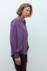 Camisa de manga larga con estampado de cuadros pequeños en tonos violeta y rojo, con cuello clásico y cierre frontal de botones.