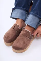 Sueco de plataforma color negro, con exterior de gamuza, interior forrado en piel sintética y detalle de corcho en el talón. Cuenta con una tira ajustable con broche metálico en el empeine.