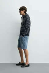 Bermuda de jean con corte regular fit, confeccionada en denim de algodón con elasticidad. Presenta diseño de cinco bolsillos, efecto lavado y cierre frontal con cremallera y botón.