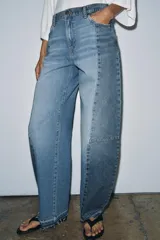 Jeans de tiro medio con diseño barrel y detalle de patchwork en denim a contraste. Cuenta con cinco bolsillos, trabillas en la cintura y cierre frontal con cremallera y botón.
