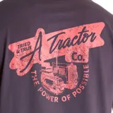 Remera gris de manga corta con cuello redondo y estampado en el pecho con el logo de Heritage Tractor Co en color coral.