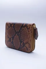 Billetera marrón tipo sobre con cierre de cremallera, confeccionada en cuero con textura tipo cocodrilo y forro textil rojo. Cuenta con múltiples ranuras para tarjetas, documentos y billetes.